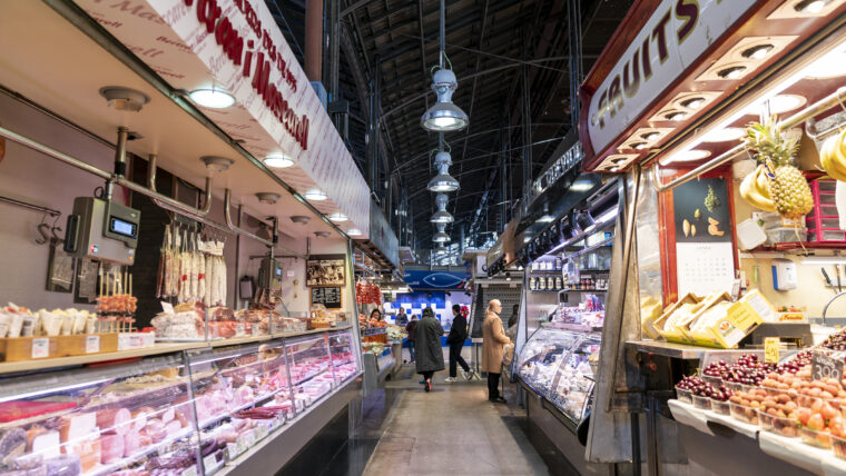 Parades del Mercat de Sant Josep - La Boqueria amb gent comprant. Parada de carns i embotits i de fruites