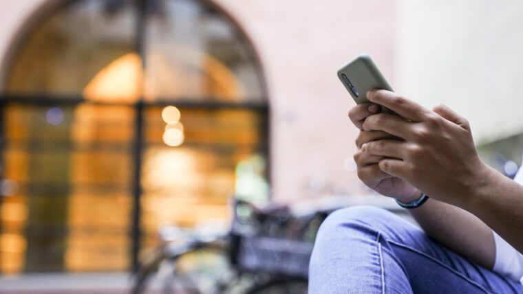 Una noia escriu amb el seu telèfon mòbil