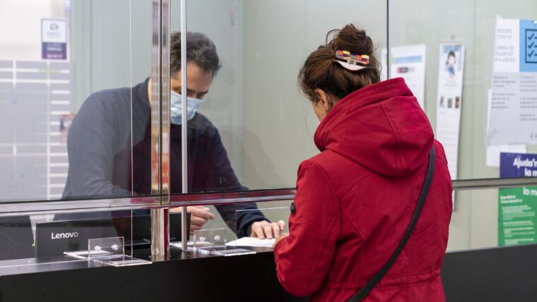 Una persona és atesa a la recepció del Centre de Serveis Socials Meridiana per un treballador municipal