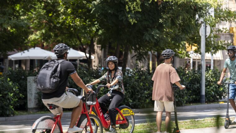 Ciclistes i patinets elèctrics circulant per un carril bici.