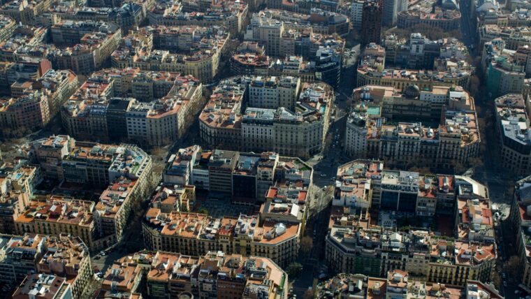 Vista aèria panoràmica de les illes de cases de l'Eixample on es s'aprecia la quadrícula del pla Cerdà. Al fons, la Torre Urquinaona, edifici d'estil brutalista