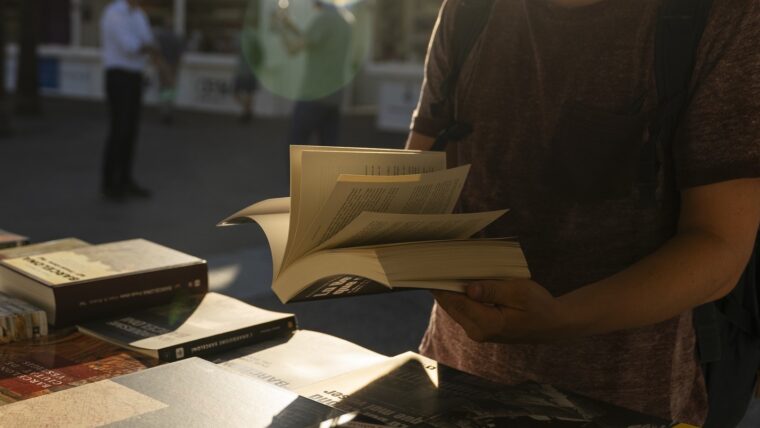 Un noi obre un llibre d'una parada de Sant Jordi