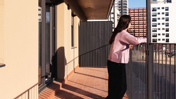 Una noia al balcó del seu habitatge d'ús públic