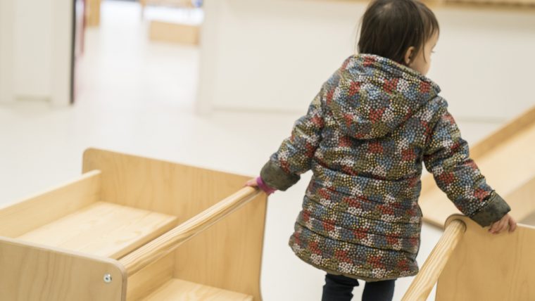 Una nena caminant entre els materials infantils d'una sala d'espera d'un CDIAP