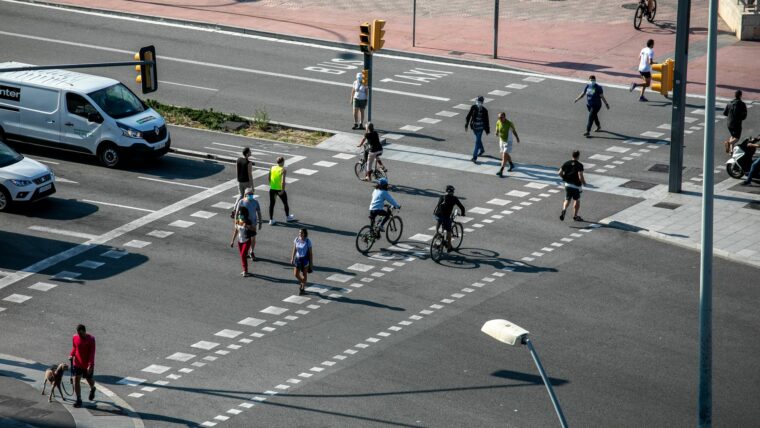 Persones i ciclistes travessant l'avinguda del Paral·lel.